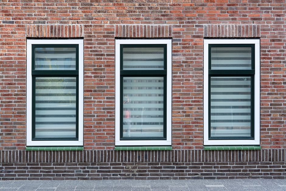 Workers fitting a window into a wall opening